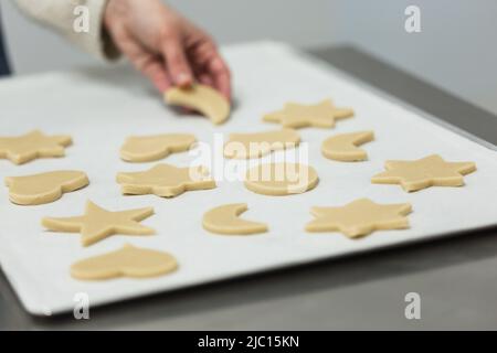 Faire cuire les biscuits en mettant des biscuits de différentes formes sur la plaque pour la cuisson Banque D'Images