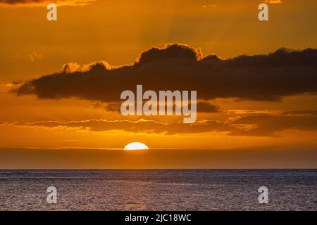Coucher de soleil derrière les nuages au-dessus de la mer à la baie de Maalaea, États-Unis, Hawaï, Maui Banque D'Images