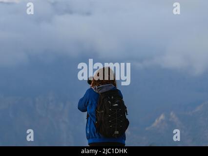 Un randonneur prend des photos du paysage des Alpes Orobie vu de la Val Seriana pendant un jour d'octobre, près de la ville de Clusone, Italie. Banque D'Images