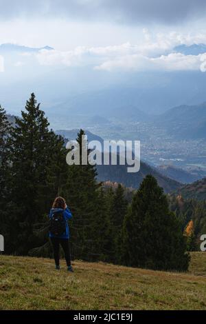 Un randonneur prend des photos du paysage des Alpes Orobie vu de la Val Seriana pendant un jour d'octobre, près de la ville de Clusone, Italie. Banque D'Images