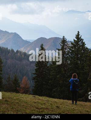 Un randonneur prend des photos du paysage des Alpes Orobie vu de la Val Seriana pendant un jour d'octobre, près de la ville de Clusone, Italie. Banque D'Images