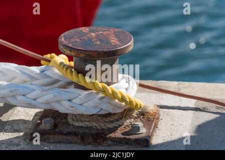 Un bollard de quai au soleil avec de lourdes lignes d'amarrage en nylon attachées en Australie Banque D'Images