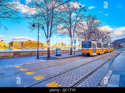 BUDAPEST, HONGRIE - 23 FÉVRIER 2022 : le tramway jaune Vintager longe le Danube sur le quai Friedrich Born, sur 23 février à Budapest, Hongrie Banque D'Images