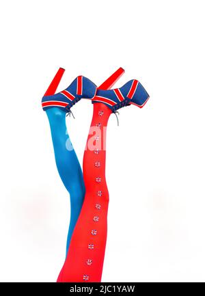 Les jambes longues femelles sont étirées verticalement. Sur eux, talons hauts élégants avec motif drapeau britannique. Banque D'Images