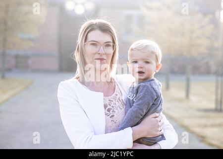 Bonne jeune mère tenant doux garçon, famille s'amusant ensemble dehors sur une belle journée ensoleillée. Photo de haute qualité Banque D'Images