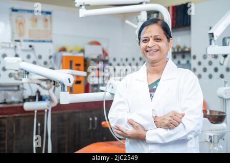 Portrait de femmes souriantes médecin dentaire debout avec les bras croisés en regardant la caméra à l'hôpital - concept de confiance, succès et Banque D'Images