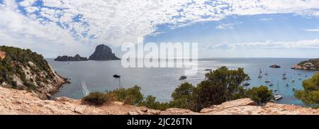 Vue panoramique sur la baie, rochers jaunes entourant la baie Cola d'Hort, pins verts et nombreux yachts. Ibiza, Iles Baléares, Espagne Banque D'Images