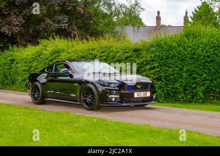 2016 Ford Mustang noir automatique à 4951cc 6 vitesses arrivant à Worden Park Motor Village pour le Festival de Leyland, Royaume-Uni Banque D'Images