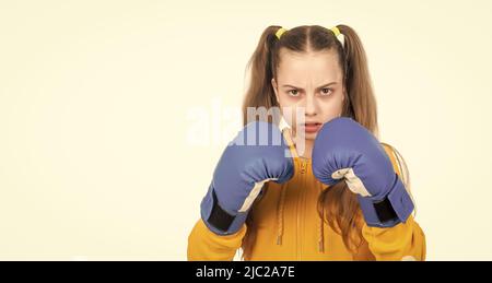 elle se battra. concentré de punching d'enfant. poing de combat. jeune fille en gants de boxe. attaque en colère. Banque D'Images