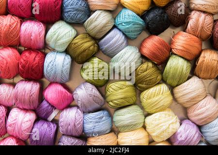 Close up photo of many colorful embroidery thread rolls made of cotton, arranged in rows. Banque D'Images