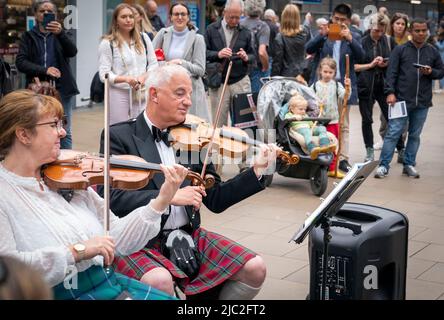 Les membres de l'Orchestre du violon écossais jouent dans une représentation pop-up à la gare Waverley d'Édimbourg, dans un court concert de musique traditionnelle de leur répertoire pour divertir les passants sur le hall avant leur prochain concert à Usher Hall samedi. Date de la photo: Jeudi 9 juin 2022. Banque D'Images