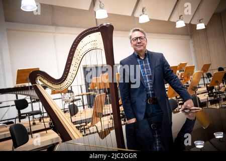 Brême, Allemagne. 09th juin 2022. Christian Kötter-Lixfeld, directeur artistique de l'Orchestre philharmonique de Brême, se trouve à côté d'une harpe dans la nouvelle salle de concert du Tabakquartile. L'Orchestre philharmonique de Brême vient de se déplacer dans sa nouvelle maison ici. Ici, ils ont leur propre hall avec plus de 400 mètres carrés d'espace et 373 sièges à leur disposition comme salle de répétition et d'événement. (À la musique dpa du quartier du tabac - Orchestre philharmonique de Brême en mouvement) crédit: Sina Schuldt/dpa/Alay Live News Banque D'Images