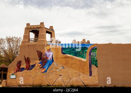 2021 05 21 Taos NM USA mur sur le centre ville stuc bâtiment de l'artisan indigène avec des outils sur la construction avec l'artiste et musicien George Chacón avec mi Banque D'Images