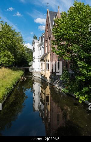 Gand, Flandre, Belgique - 06 13 2020 vieilles maisons en pierre de brique reflétées dans une crique au ciel bleu Banque D'Images