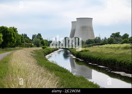 Vilvoorde, Brabant flamand, Belgique - 06 04 2022 - cycliste sur une piste cyclable au bord de la rivière Senne avec deux cheminées de centrales électriques à l'arrière Banque D'Images