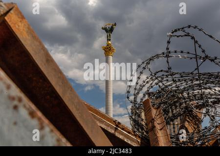 Kiev, Ukraine. 09th juin 2022. Le monument de l'indépendance sur la place du Maïdan est vu à travers des barricades de routes métalliques et des barbelés dans une vieille ville de Kiev, Ukraine sur 9 juin 2022. Alors que la Fédération de Russie envahissait l'Ukraine il y a 3 mois et demi, des combats acharnés se poursuivent dans l'est du pays. La capitale, Kiev, reste en sécurité relative, bien que des rappels de la guerre tels que des sacs de sable protecteurs, des barrages routiers, des symboles nationaux et anti-guerre soient présents dans toute la ville. (Photo par Dominika Zarzycka/Sipa USA) crédit: SIPA USA/Alay Live News Banque D'Images