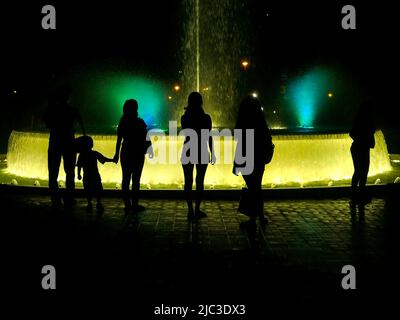 Les silhouettes jouent dans les fontaines du circuit d'eau magique du parc de réserve à Lima. Banque D'Images