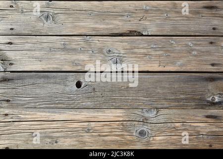 Plancher en bois fait de vieilles planches avec des nœuds et des fissures avec des clous rouillés, abîmé avec du sable. Grunge l'arrière-plan Banque D'Images