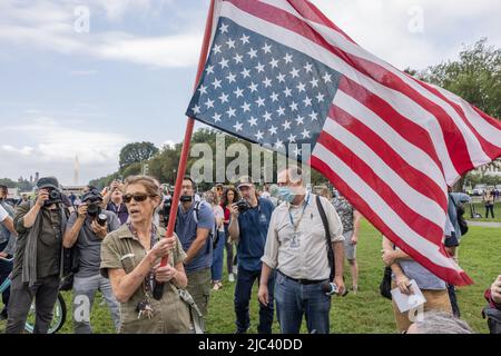 WASHINGTON, D.C., – 18 septembre 2021 : un manifestant marque un drapeau près des médias avant un rassemblement « Justice pour J6 ». Banque D'Images