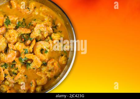 Délicieux moqueca aux crevettes avec un fond orange vif. Banque D'Images