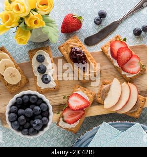 Craquelins avec différentes garnitures fraîches sur une planche en bois. Banque D'Images