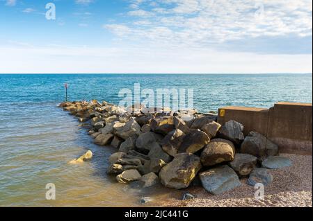 Groynes de roche sur la plage de Sidmouth, Devon, Angleterre Banque D'Images