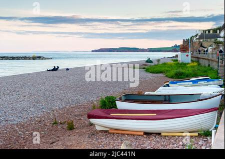 Sidmouth front de mer au crépuscule avec de petits bateaux en premier plan, East Devon, Angleterre Banque D'Images