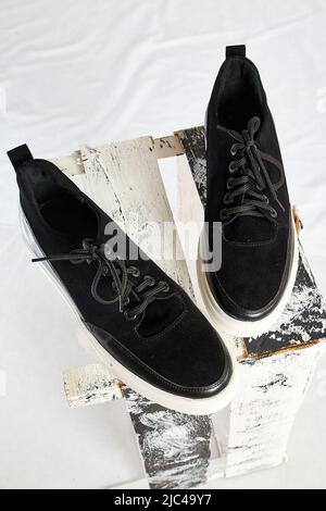 Baskets en daim tendance. Chaussures de sport. Des chaussures ou des mocassins coûteux isolés sur fond blanc avec des choses différentes. Séance photo professionnelle Banque D'Images