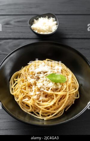 Pâtes italiennes dans une assiette noire. Cacio e Pepe - pâtes italiennes Banque D'Images