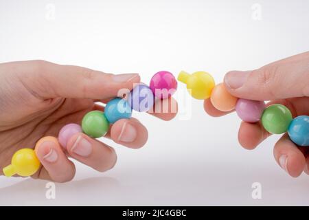 Tenir la main perles de couleur avec l'expression du visage sur fond blanc Banque D'Images