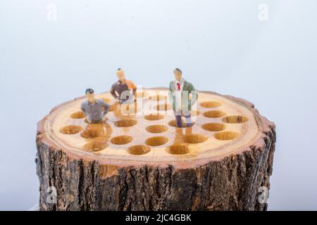 Peu de figurines hommes places sur un journal en bois Banque D'Images