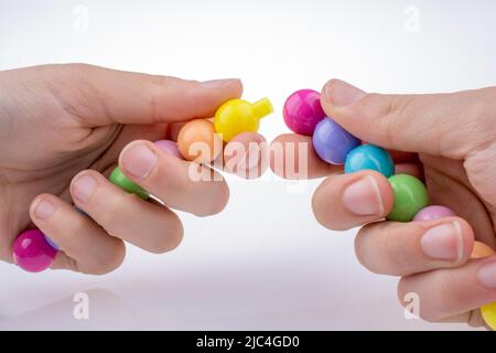 Tenir la main perles de couleur avec l'expression du visage sur fond blanc Banque D'Images