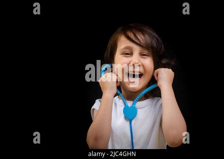 Petit garçon intelligent futur médecin tient le stéthoscope Banque D'Images