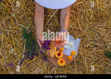 Une femme tient le vin dans des verres. Pique-nique dans le champ de lavande. Mise au point sélective. Banque D'Images