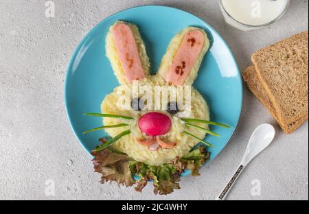 Un lapin drôle de purée de pommes de terre et de saucisses pour le petit déjeuner repas des enfants sur une assiette bleue Banque D'Images