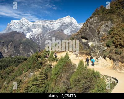 Trekker avec un guide et un portier se dirigeant vers Tengboche à partir de Namche Bazar avec Kongde RI (6187m) en arrière-plan. Banque D'Images