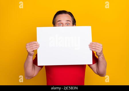 Photo de l'impressionné funky gars pensioner habillé rouge t-shirt vide espace board close face isolé couleur jaune fond Banque D'Images