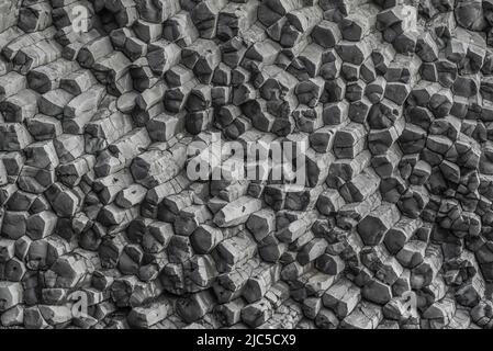 Les colonnes hexagonales de basalte de Reynisfjall, la montagne de la plage de Reynisfjara, en Islande, forment un fond géométrique naturel Banque D'Images