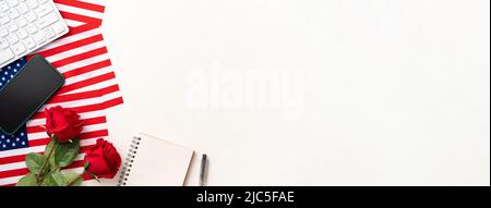 Concept de jour de l'indépendance ou jour du souvenir avec drapeau national, rose et fournitures de bureau sur fond de table blanche. Banque D'Images