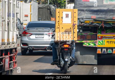 SAMUT PRAKAN, THAÏLANDE, LE 19 2022 MARS, Un homme fait une moto dans la rue avec des boîtes dans un embouteillage Banque D'Images