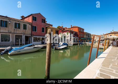 Petit canal de mer avec des bateaux amarrés dans l'île de Murano, lagon de Venise, Vénétie, Italie. Cette île est célèbre pour la production de verre artistique. Banque D'Images