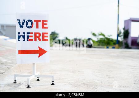Votez ici le tableau d'affichage placé près du kiosque de vote pour montrer les directives aux électeurs montrant avec l'espace de copie. Banque D'Images