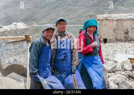 Quatre jeunes Tibétains font une pause pour réparer une partie du monastère de Ganden à Lhassa, au Tibet. Banque D'Images