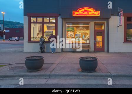 Duluth, Minnesota, États-Unis – 29 mai 2022 : deux personnes regardent dans la fenêtre de la fabrique de chocolat des montagnes Rocheuses, dans le district des canaux Banque D'Images