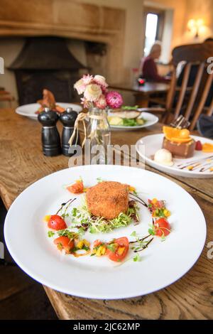 Cuisine moderne dans un pub anglais traditionnel - gâteau au saumon fumé et à l'écrevisse. Banque D'Images