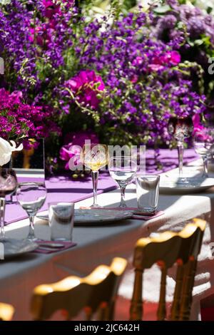 Décoration table de fête avec fleurs violettes et blanches et verrerie sur nappe. Mise au point sélective Banque D'Images