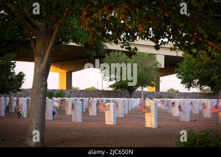 Le soleil se couche sur les tombes d'un cimetière national de l'ouest du Texas la nuit précédant le jour du souvenir. Banque D'Images