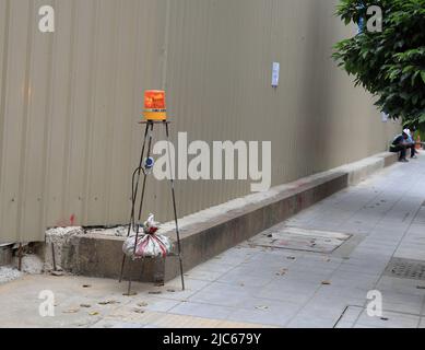 feux d'avertissement sur le poteau en acier, vue rapprochée d'un voyant d'avertissement jaune sur le poteau en métal blanc et rouge à côté du chantier de construction. Banque D'Images