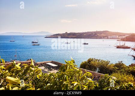 Vue sur la plage de Bodrum depuis le château. Bateaux à voile, yachts à la mer Égée avec maisons blanches traditionnelles sur les collines de la ville de Bodrum en Turquie Banque D'Images