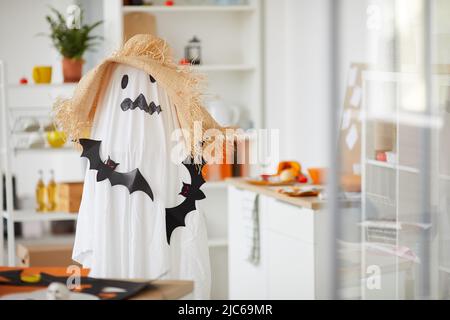 Enfant méconnaissable en costume d'Halloween effrayant de fantôme défait avec des rats noirs en papier debout dans wotkshop Banque D'Images